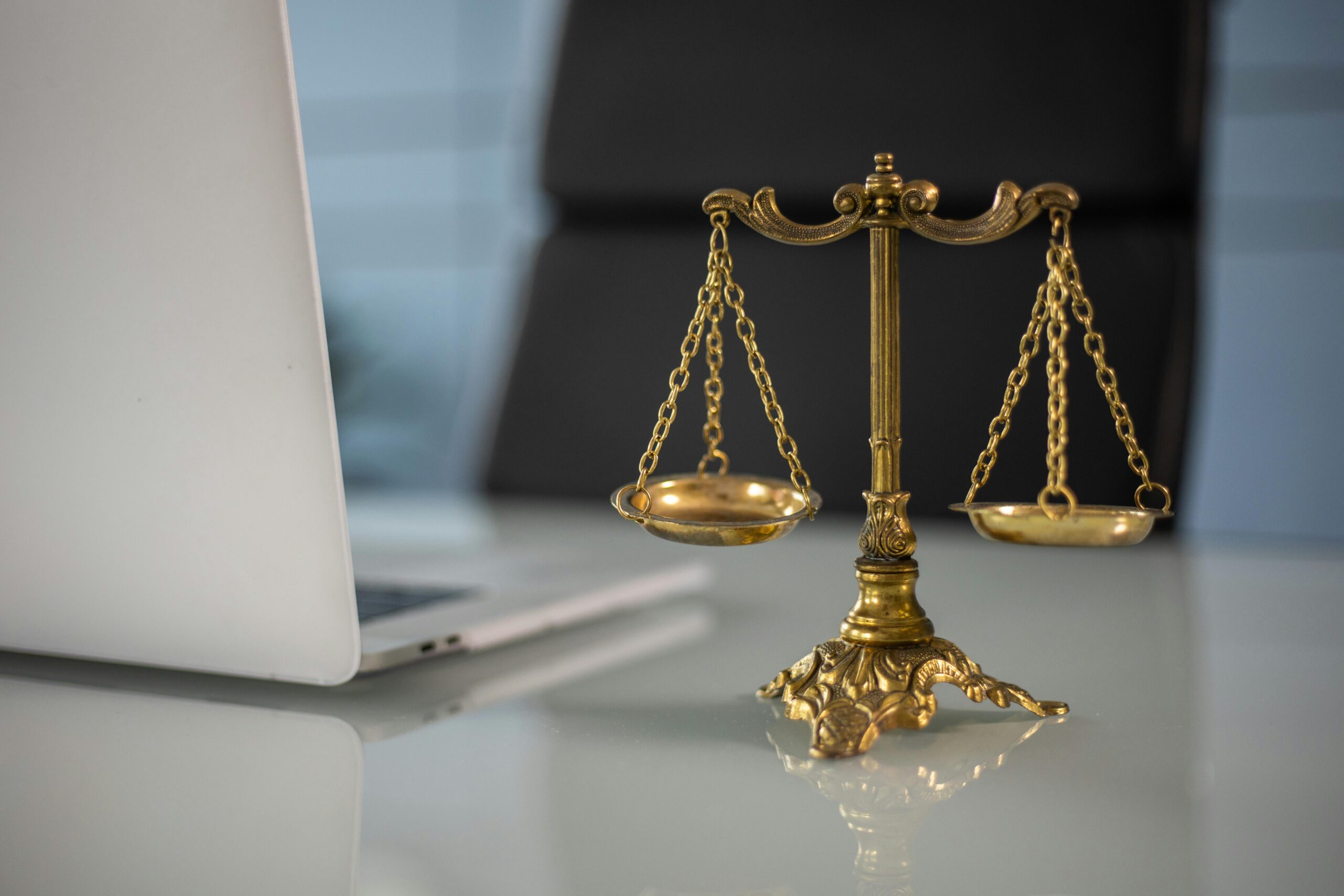 The scales of justice sit next to a laptop