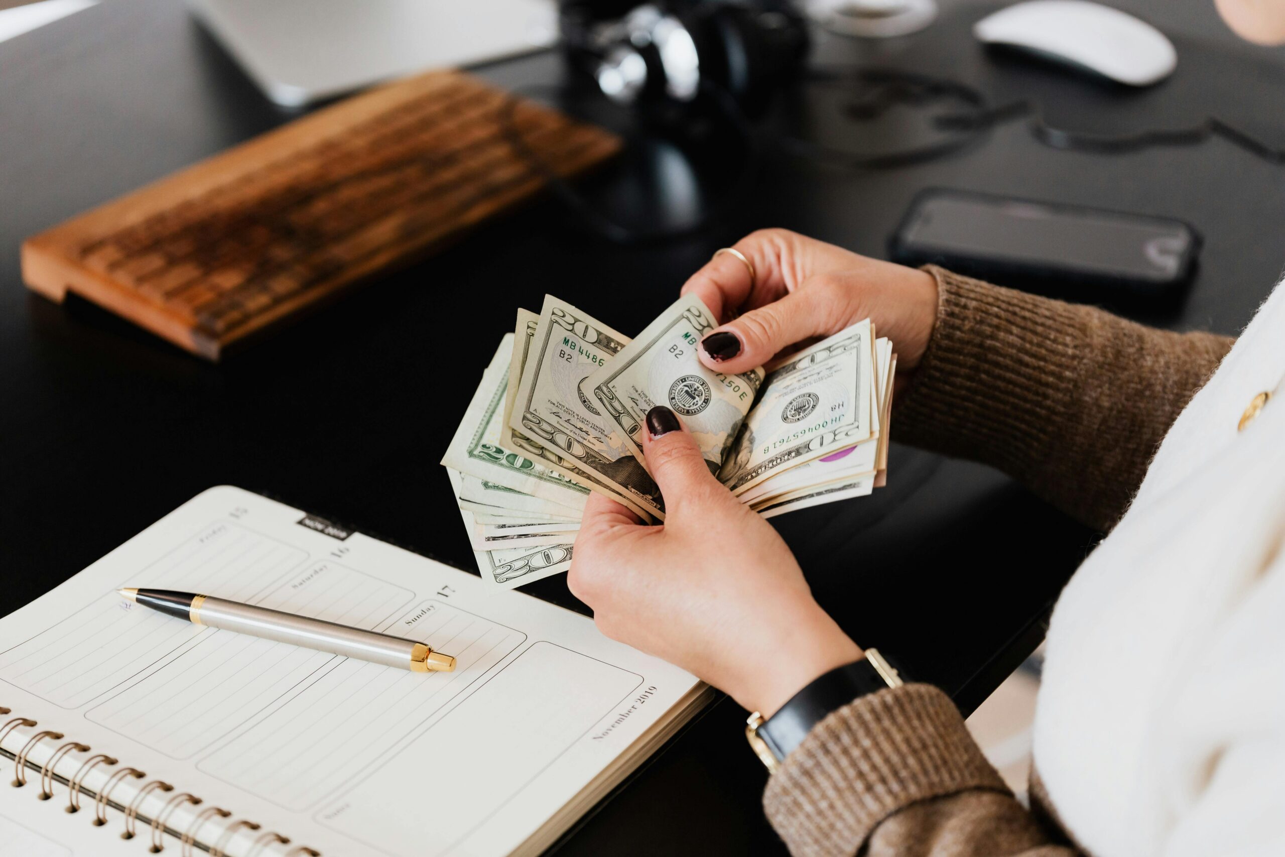 Woman's hands counting wad of cash.