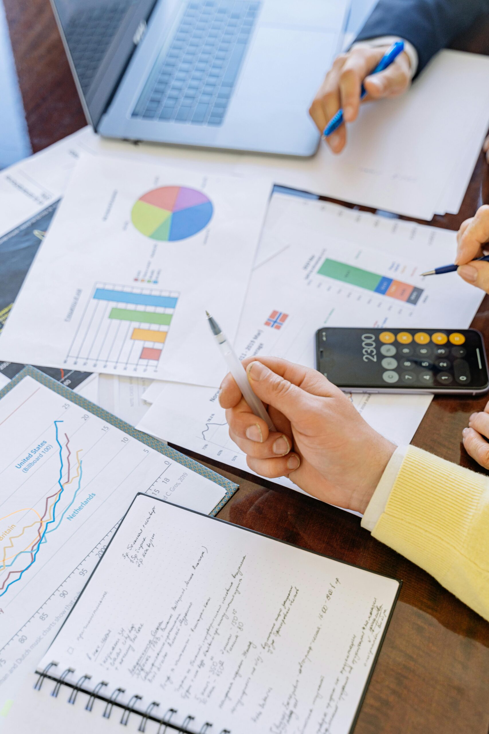 Hands pointing at documents of charts and graphs